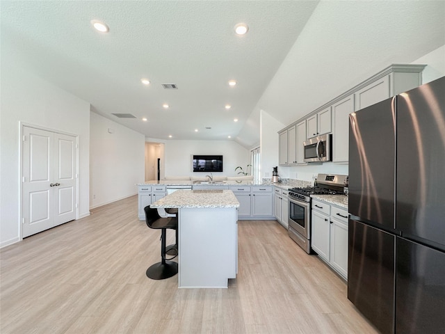 kitchen featuring stainless steel appliances, a peninsula, gray cabinets, and visible vents