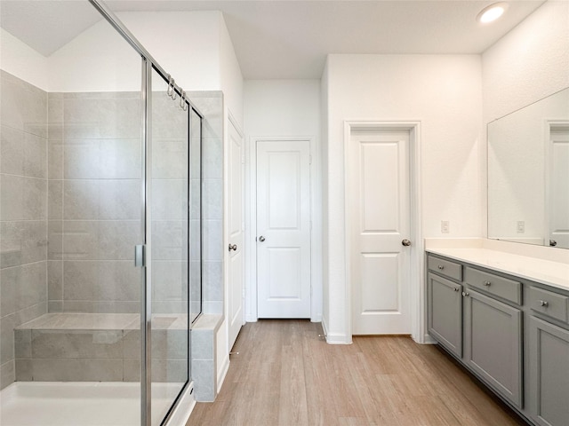 bathroom with recessed lighting, a shower stall, vanity, and wood finished floors