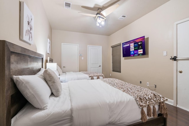 bedroom with baseboards, visible vents, dark wood finished floors, and a ceiling fan