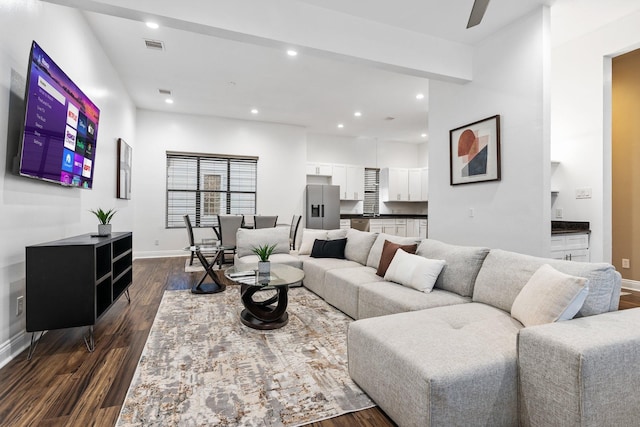 living area featuring visible vents, baseboards, dark wood-type flooring, and recessed lighting