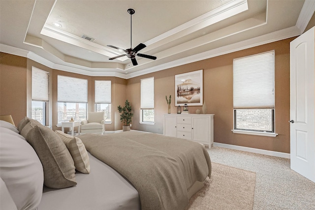 bedroom with ornamental molding, a tray ceiling, and visible vents