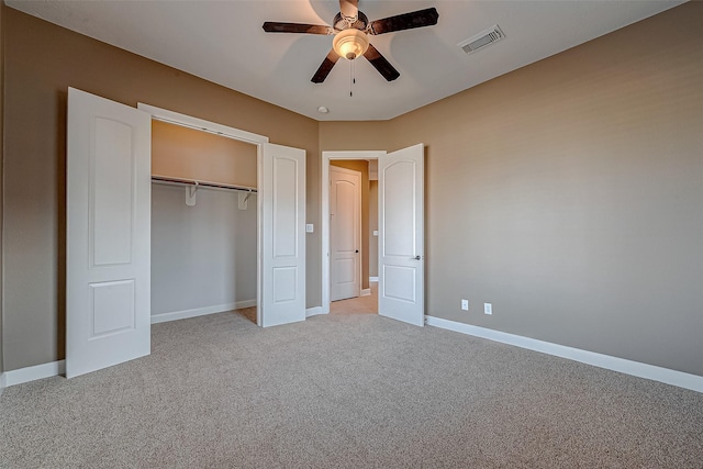 unfurnished bedroom with a closet, visible vents, light carpet, ceiling fan, and baseboards