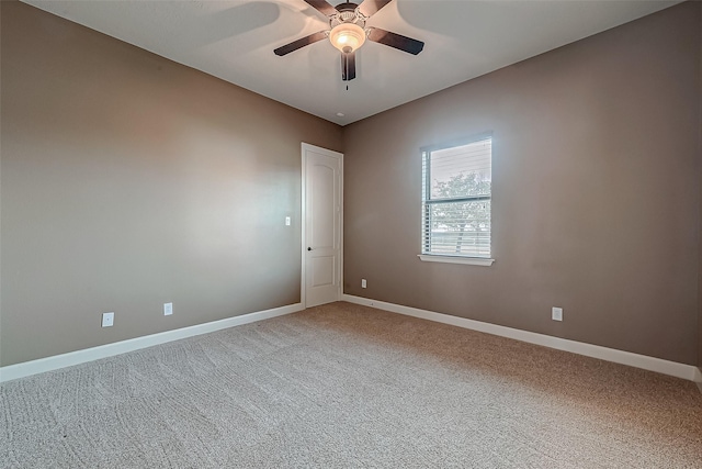 spare room featuring a ceiling fan, carpet, and baseboards