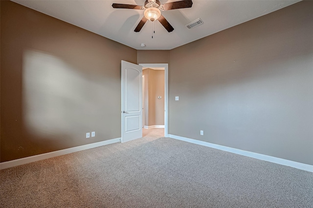 unfurnished room featuring light carpet, a ceiling fan, visible vents, and baseboards