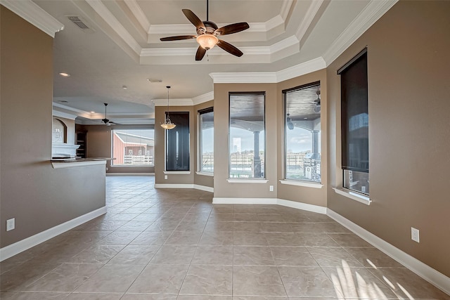 spare room featuring baseboards, visible vents, ceiling fan, a tray ceiling, and crown molding