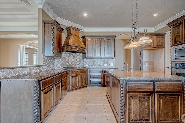 kitchen featuring light stone counters, light tile patterned floors, stainless steel appliances, backsplash, and premium range hood