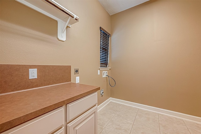 laundry area featuring light tile patterned floors, cabinet space, baseboards, hookup for an electric dryer, and washer hookup