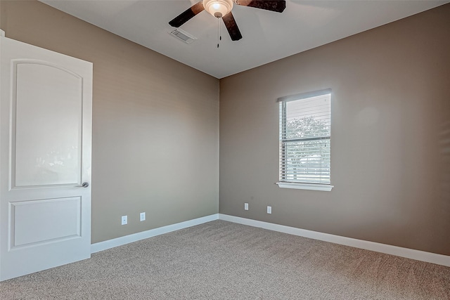 carpeted empty room featuring baseboards, visible vents, and a ceiling fan