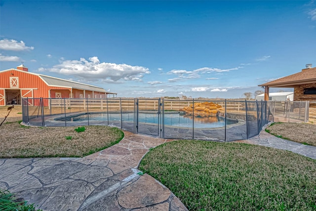 view of swimming pool with a fenced in pool, an outbuilding, a yard, and fence