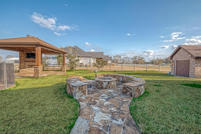 view of yard with fence, a fire pit, and a patio