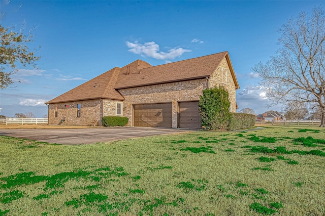 back of house featuring a garage, a yard, fence, and driveway