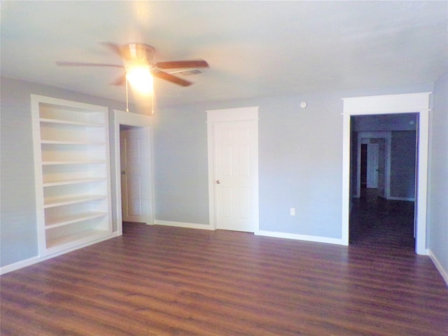 spare room featuring built in features, baseboards, and wood finished floors