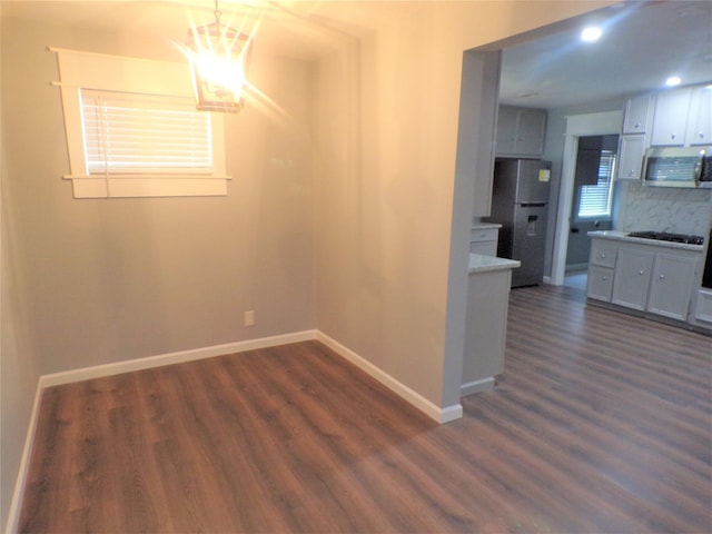 interior space with an inviting chandelier, baseboards, dark wood finished floors, and recessed lighting