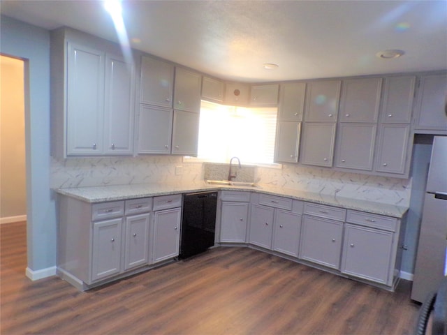 kitchen featuring dishwasher, backsplash, a sink, and gray cabinets