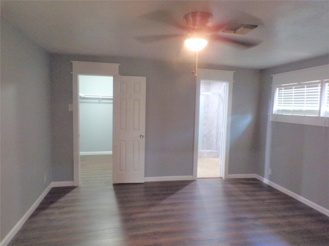 empty room with baseboards, visible vents, and wood finished floors