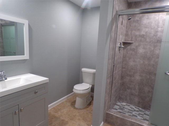 full bathroom with toilet, a stall shower, baseboards, and vanity