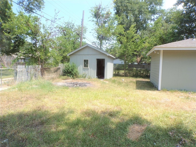 view of yard with an outdoor structure, a shed, and fence