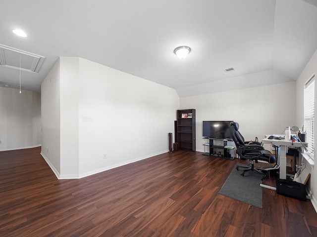 office space with wood finished floors, visible vents, baseboards, vaulted ceiling, and attic access