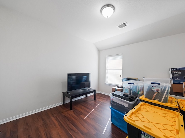 office featuring baseboards, visible vents, vaulted ceiling, and wood finished floors