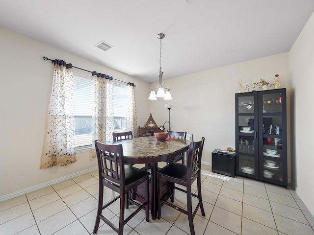 dining space with light tile patterned floors, visible vents, and baseboards