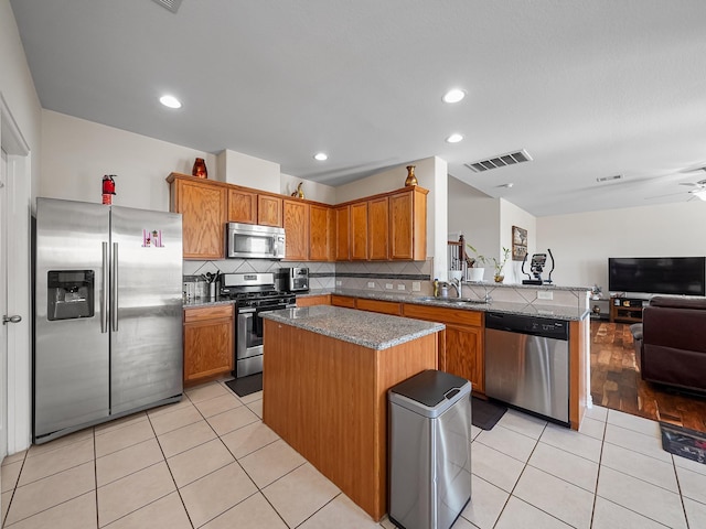 kitchen with light tile patterned floors, visible vents, open floor plan, stainless steel appliances, and a sink