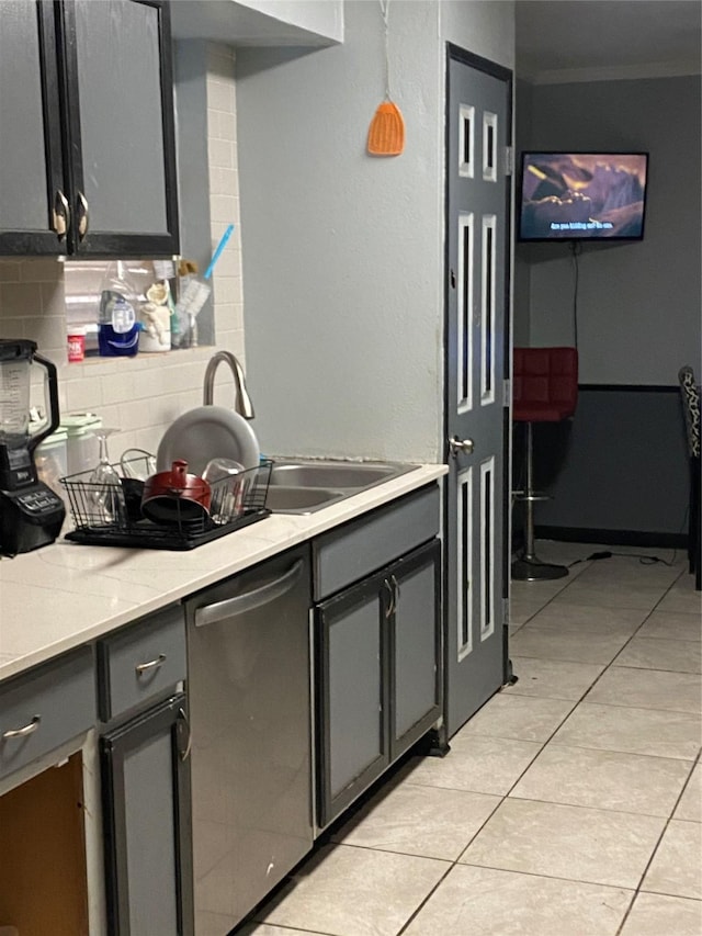 kitchen featuring crown molding, light tile patterned floors, tasteful backsplash, a sink, and dishwasher