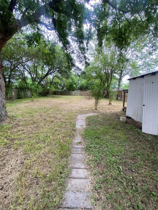 view of yard with fence and an outbuilding