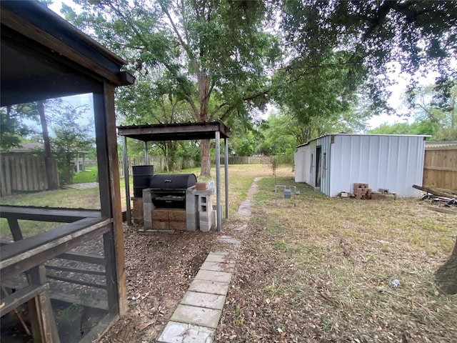 view of yard featuring a fenced backyard, a storage unit, and an outdoor structure