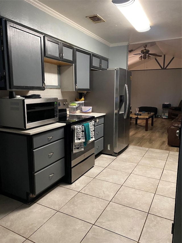 kitchen featuring light tile patterned flooring, stainless steel appliances, light countertops, ornamental molding, and decorative backsplash