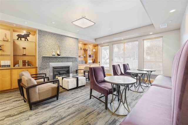 living room with a large fireplace, built in shelves, visible vents, and recessed lighting