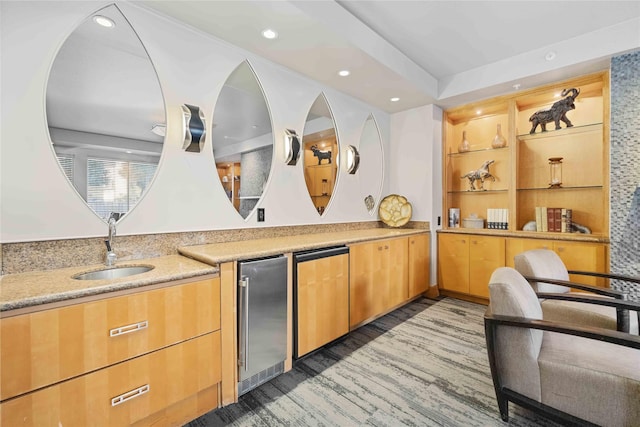 kitchen featuring fridge, wood finished floors, a sink, and recessed lighting