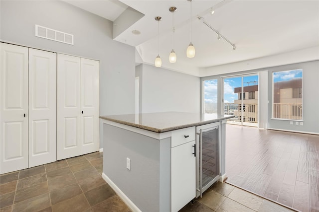 kitchen with wine cooler, a kitchen island, visible vents, open floor plan, and pendant lighting