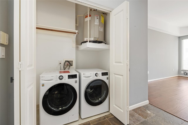 laundry area featuring laundry area, washing machine and dryer, electric water heater, and baseboards