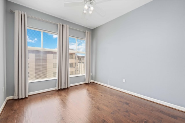 empty room with dark wood-style flooring and baseboards