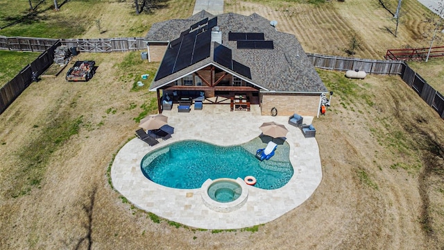 view of swimming pool featuring a patio area, a fenced backyard, and a pool with connected hot tub