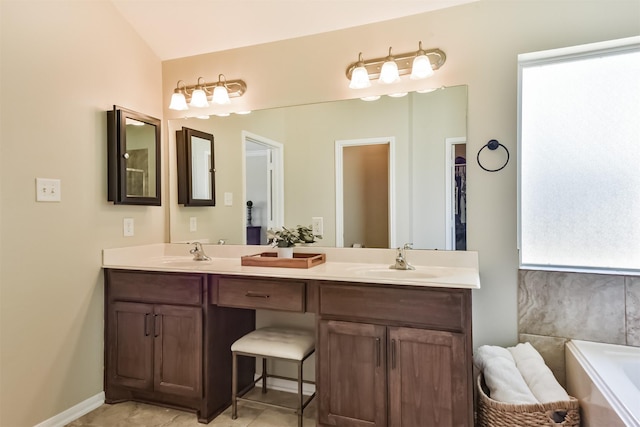 bathroom featuring double vanity, tile patterned flooring, a bathtub, and a sink