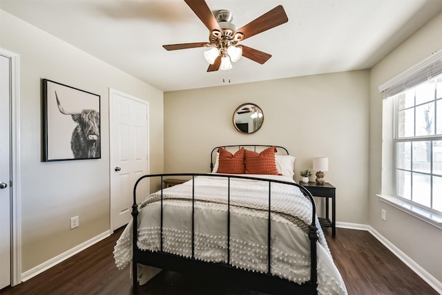 bedroom with a ceiling fan, dark wood-style flooring, and baseboards