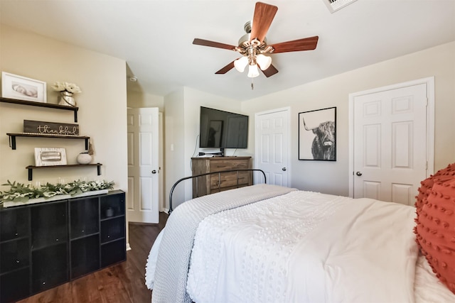 bedroom with a ceiling fan, visible vents, and dark wood finished floors