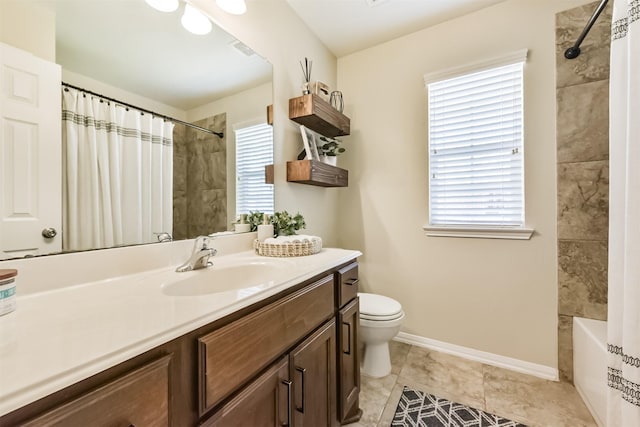 bathroom with baseboards, plenty of natural light, vanity, and toilet