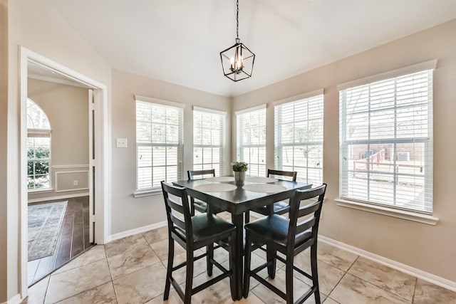 dining area featuring a notable chandelier, baseboards, and a wealth of natural light