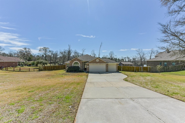 view of front of property featuring an attached garage, driveway, a front yard, and fence