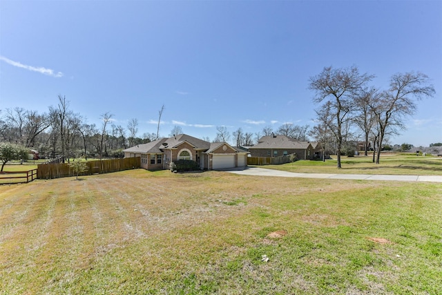 view of front of house featuring an attached garage, fence, driveway, and a front lawn