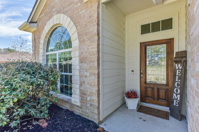 entrance to property featuring brick siding