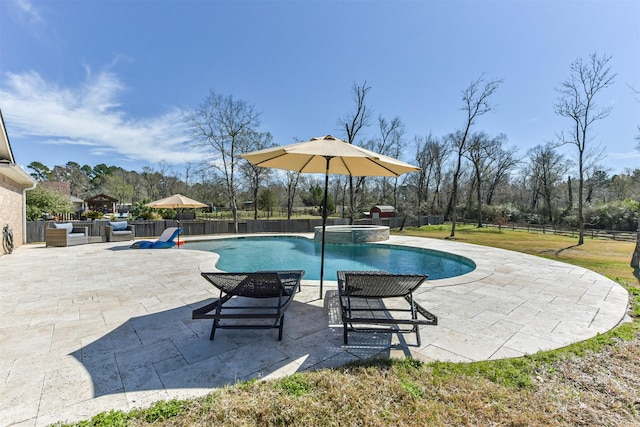 view of swimming pool featuring a patio area, fence, and a pool with connected hot tub