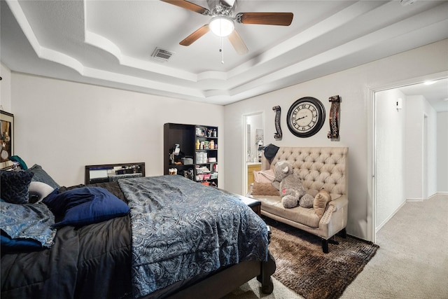 bedroom with carpet floors, a raised ceiling, visible vents, ceiling fan, and baseboards