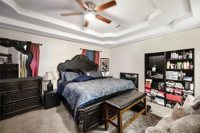 bedroom with carpet, a raised ceiling, visible vents, and ceiling fan