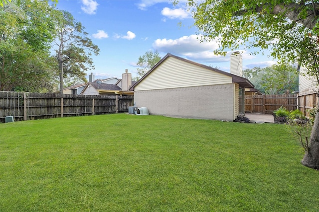 view of yard with a fenced backyard and central air condition unit