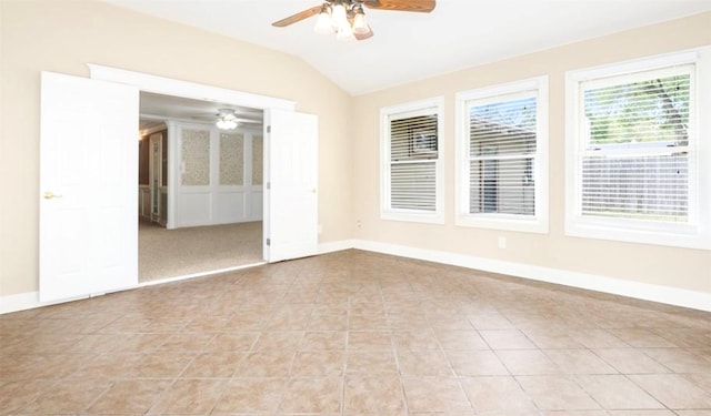 spare room featuring ceiling fan, baseboards, vaulted ceiling, and light tile patterned flooring