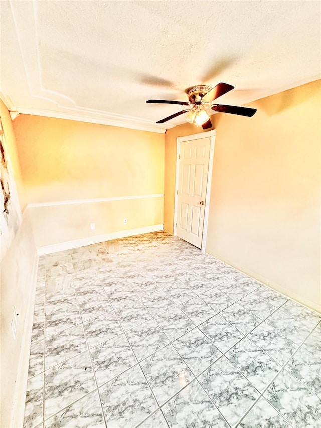 spare room featuring ceiling fan, a textured ceiling, and baseboards