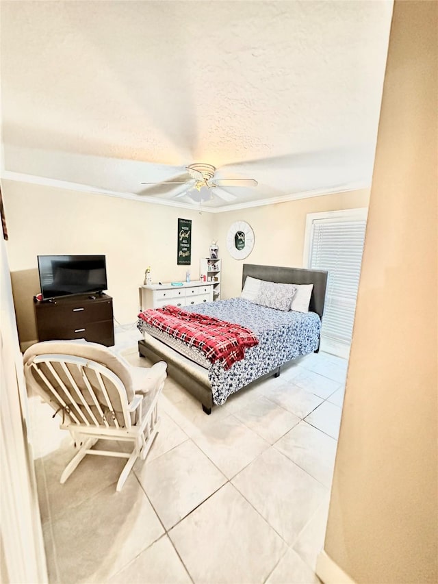 bedroom featuring a textured ceiling, tile patterned flooring, a ceiling fan, and crown molding